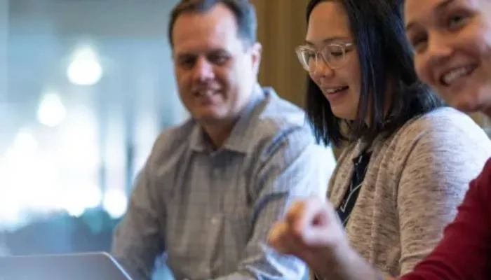 3 people in a row smiling
